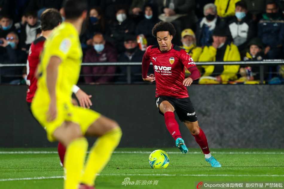 比利亚雷亚尔球员庆祝首开纪录的进球，全队拥抱在一起，主场球迷看台一片沸腾的黄色海洋