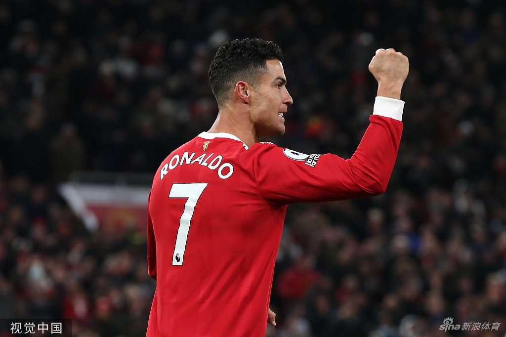 C罗主罚点球前一瞬间的特写，他深吸一口气，眼神坚定地注视着球门，老特拉福德全场屏息，空气中弥漫着紧张而期待的气息。