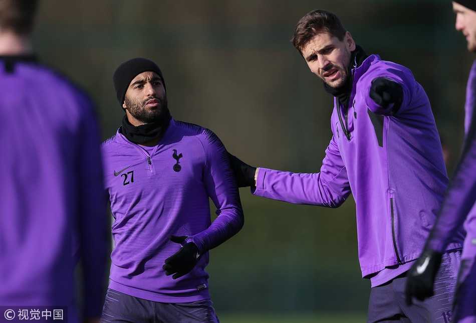 孙兴慜与热刺队友在训练中轻松交谈，他开怀大笑，双手比划着，显然正在分享一个有趣的话题，团队气氛十分融洽