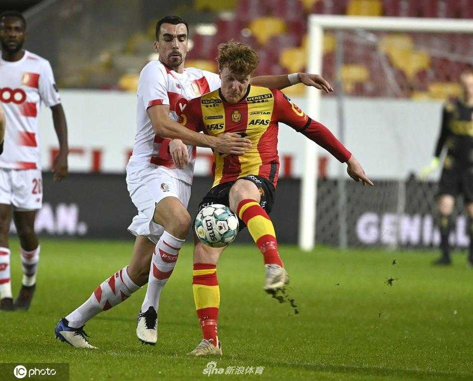 标准列日的球员们肩并肩站在客队球迷看台前，他们手拉手向远道而来的 supporters 鞠躬致谢。看台上红色的围巾如同燃烧的烈焰，将球员和球迷的心紧紧连接在一起，共同庆祝这个属于他们的完美夜晚。