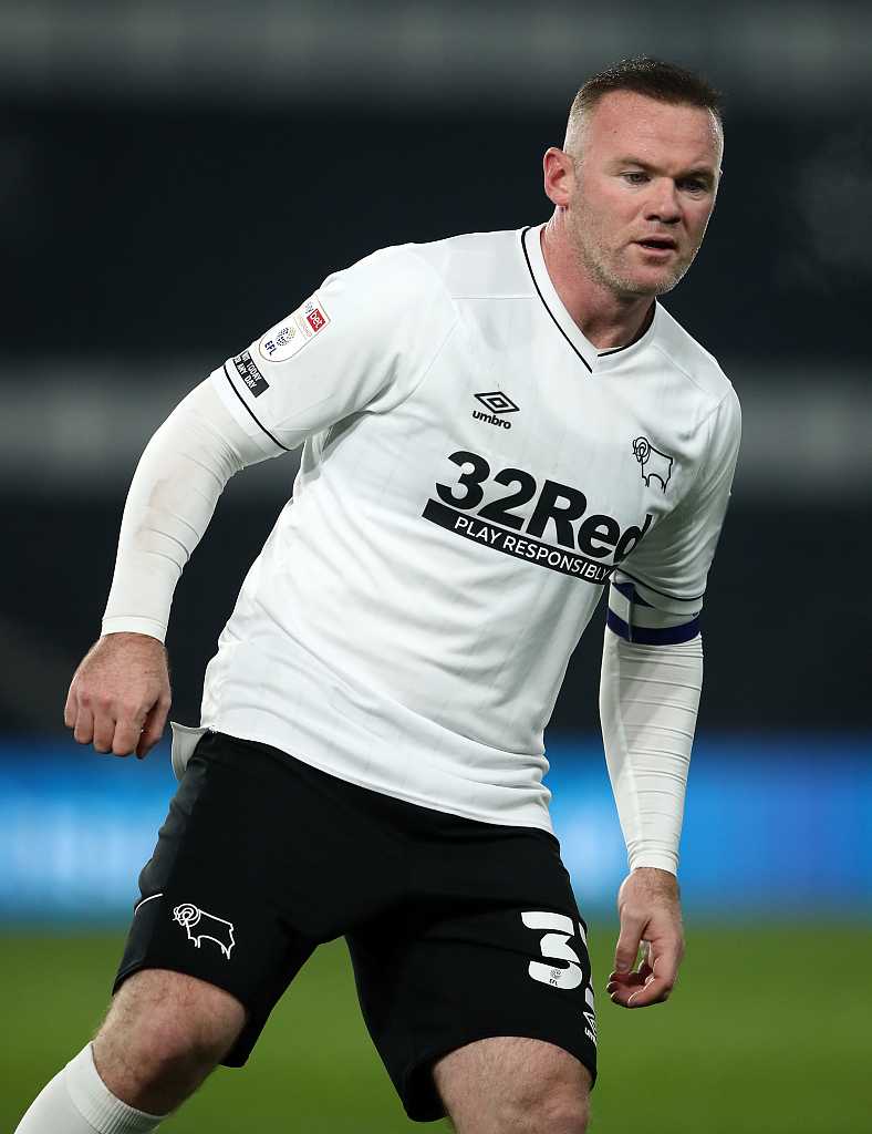 鲁尼在比赛中神情专注，正欲起脚传球，眉宇间透露出球队核心的沉稳与焦急