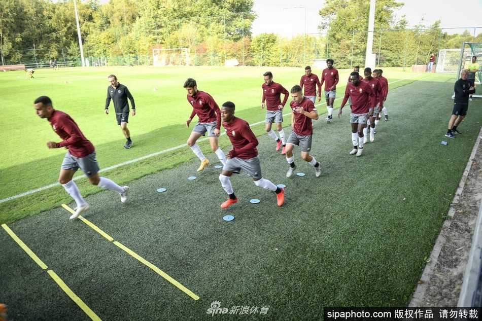 夕阳将训练场染成一片金黄色的战场，两名球员在边线附近展开激烈争抢，身体对抗迸发出的力量感几乎要溢出画面，草屑随着他们的拼抢而飞溅，这是足球最原始的激情。