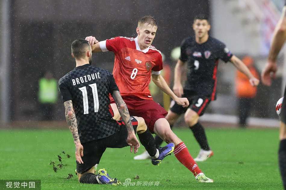 看台上的克罗地亚球迷们挥舞着巨大的格子国旗，他们脸上画着彩绘，激动的泪水与欢呼声交织在一起