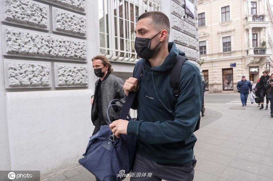 莫德里奇与科瓦契奇身穿休闲装，肩并肩走在萨格勒布街头，魔笛面带微笑侧身与队友交谈，气氛轻松融洽。