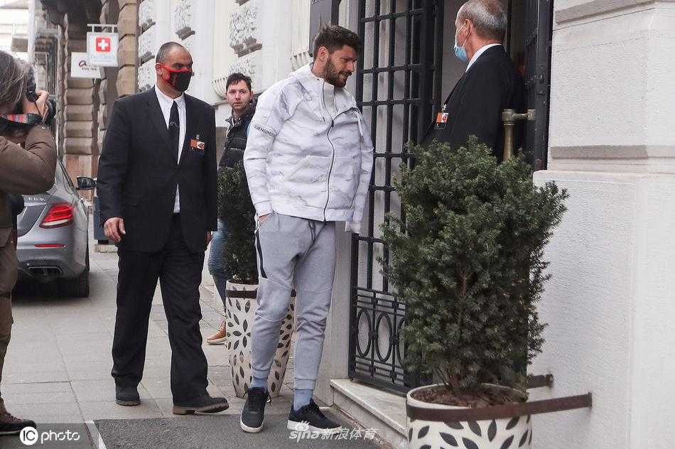 科瓦契奇拖着黑色行李箱，身着深色运动外套，表情专注地走在萨格勒布的人行道上，仿佛正在脑海中演练着即将到来的中场对抗。