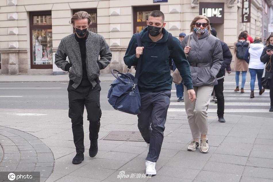 克罗地亚国家队另一位球员独自拖着行李箱走过斑马线，神情淡然，显然已习惯了这种穿梭于俱乐部与国家之间的奔波生活。