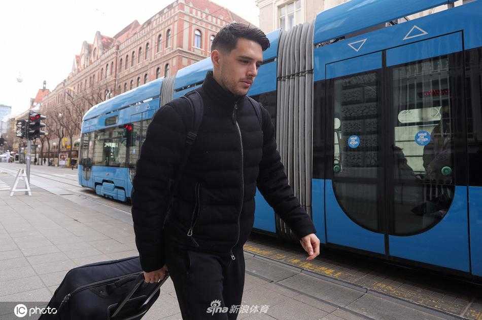 从背面视角拍摄的莫德里奇，他背着书包，在人行道上步履坚定地走向集合点，这一背影仿佛承载着整个国家足球的希望与重托。