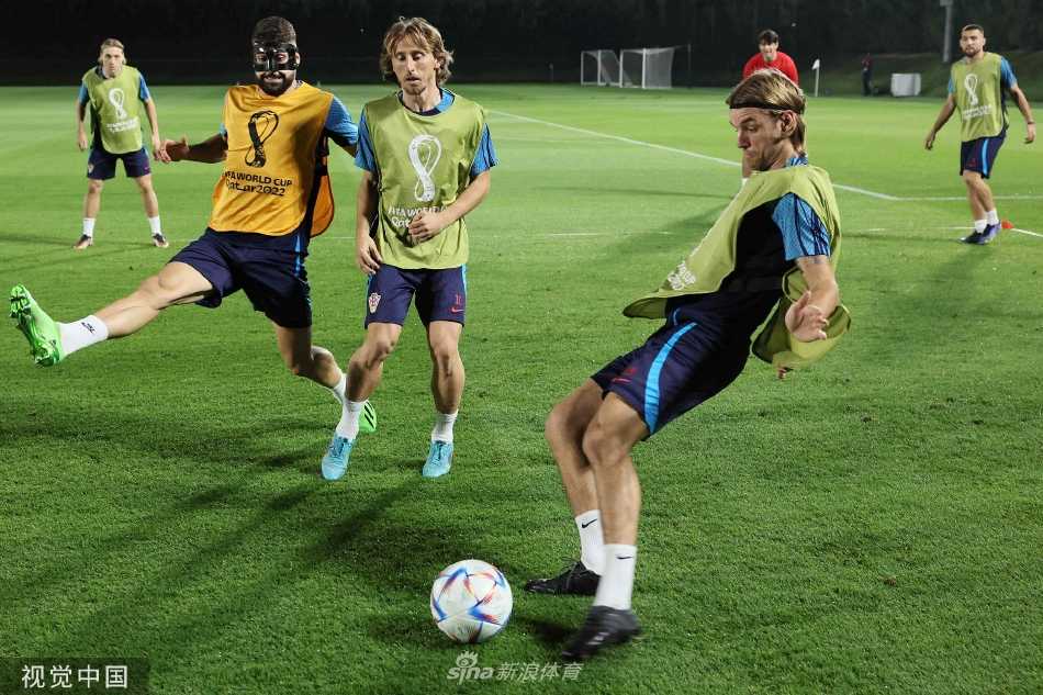 训练间隙，克罗地亚队员围成一圈进行拉伸放松。中间的核心球员神情轻松，正与队友交谈，全队展现出团结一致、松弛有度的备战状态。