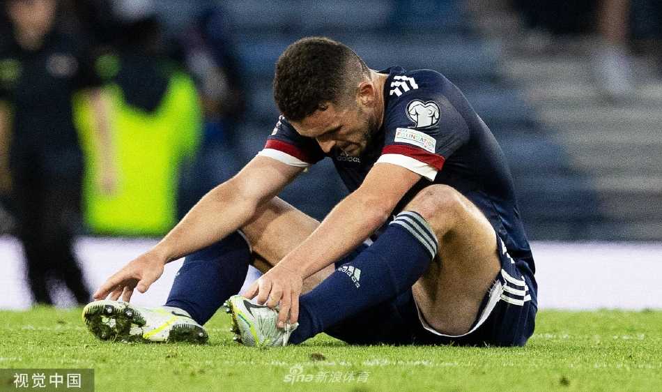 苏格兰球员麦克格雷戈破门后与队友庆祝，背景中乌克兰门将布什坎神情略显沮丧