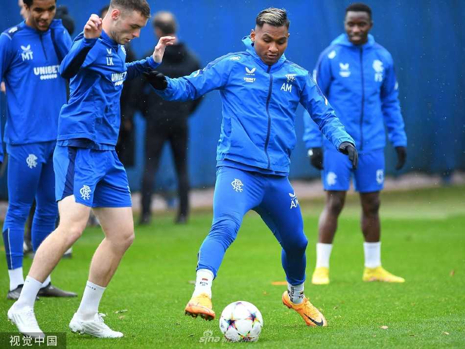 球队助理教练正在向围成一圈的球员们讲解战术要点，每个人都在凝神倾听。