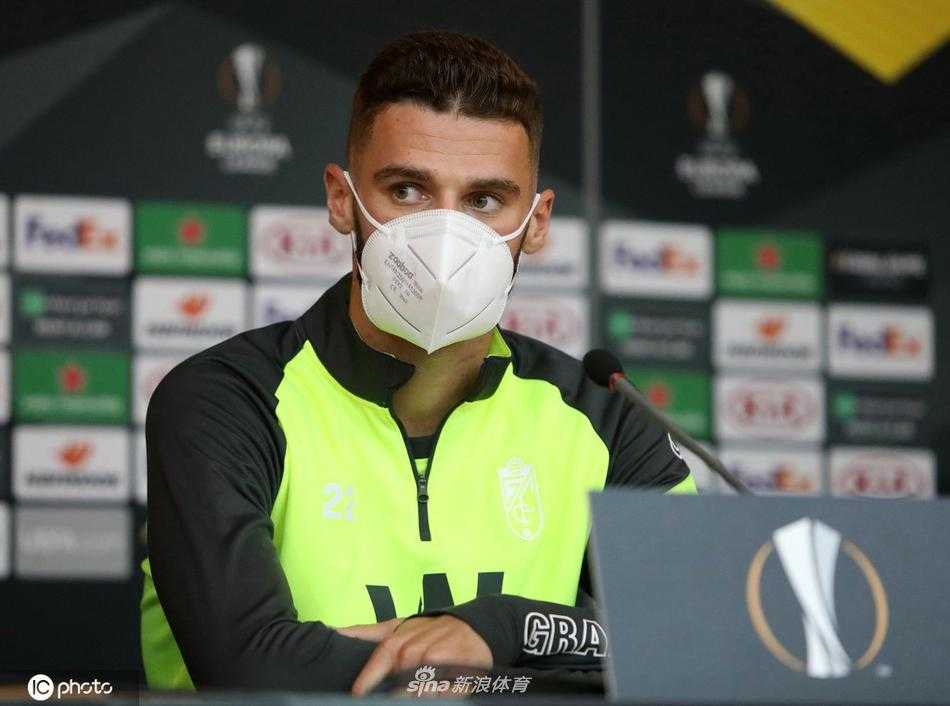 主教练迭戈·马丁内斯在空荡的新闻厅里眉头紧锁，眼神中透露出对远方战事的忧虑与坚定