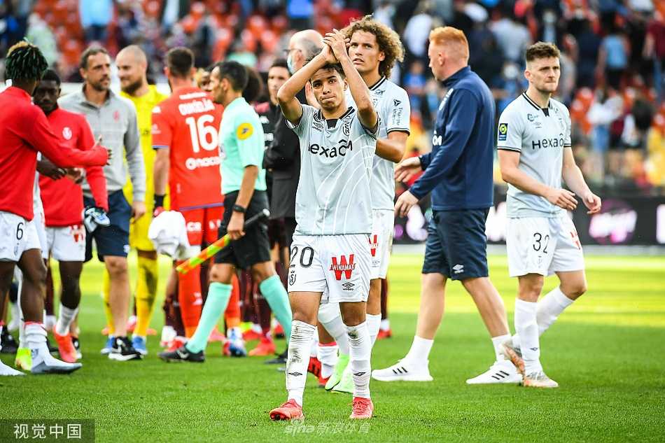 梅斯前锋麦加侧身凌空抽射破门瞬间，他的身体几乎与地面平行，眼神死死盯着飞向球门的皮球，草屑在他脚下飞溅