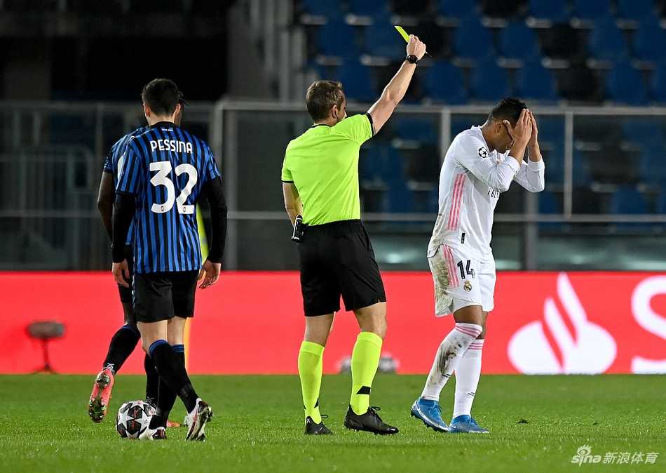 皇马后卫纳乔飞身铲球，与亚特兰大球员戈森斯激烈拼抢，双方的眼神中都充满了对球权的极度渴望，草屑飞扬间，完美诠释了欧冠淘汰赛阶段每一寸草皮必争的惨烈程度。