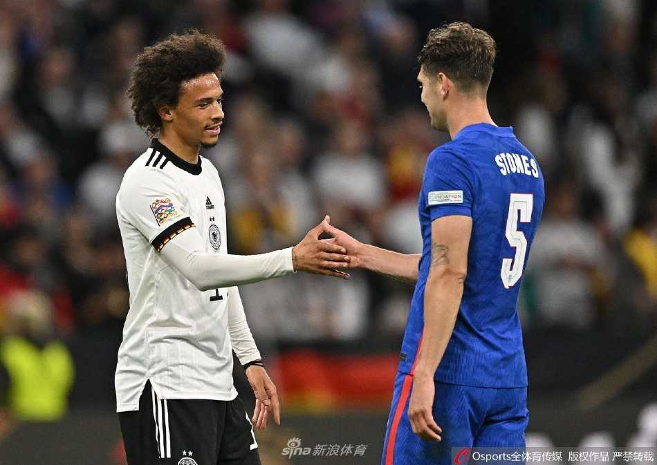 德国队前锋托马斯·穆勒在比赛中带球突破，面对英格兰防守球员的围堵，表情专注坚决。