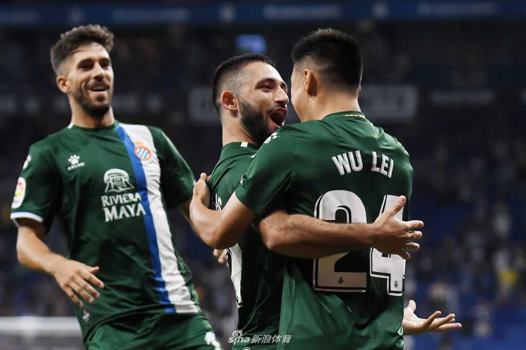 武磊张开双臂在场上狂奔庆祝，身后的巨大广告牌和看台上挥舞的球迷围巾，共同构成了这幅名为“征服”的画面。