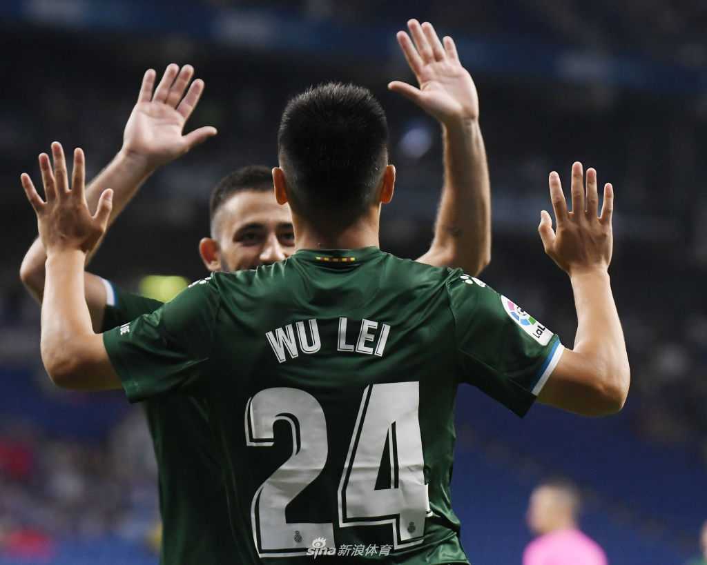 进球后的武磊被队友团团围住，他的脸上洋溢着灿烂的笑容，巴尔加斯更是激动地从身后紧紧抱住他，分享这份属于全队的喜悦。