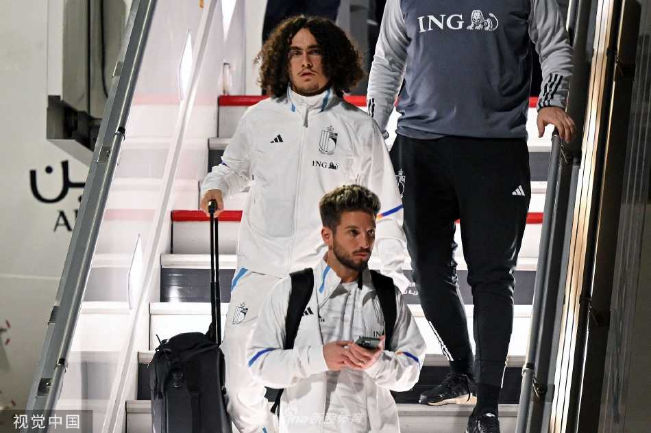 阿扎尔向接机人群挥手致意，展现出比利时队长亲民一面和团队轻松氛围