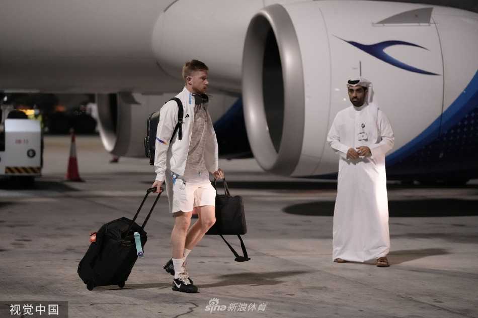 比利时国脚们排队登上球队大巴，统一红色着装形成一道亮丽的移动风景线