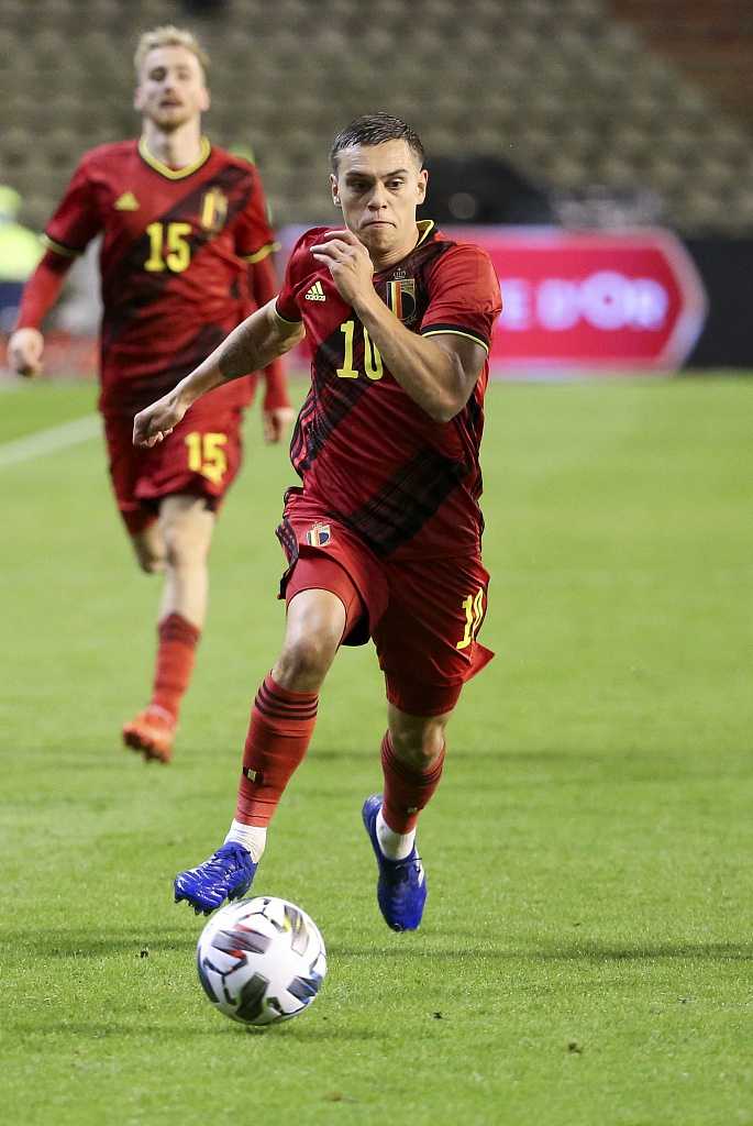 比利时队球员巴舒亚伊在比赛中破门瞬间，他全神贯注地盯着皮球，身体姿态舒展，这一刻他就是门前最冷静的杀手。