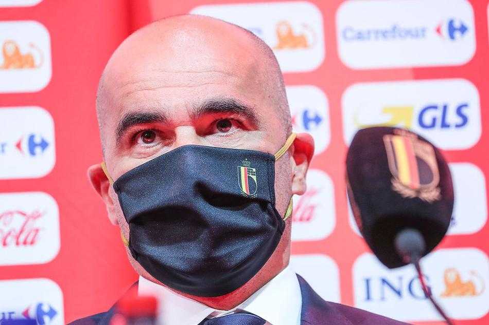 马丁内斯在发布会现场神情专注，身着笔挺衬衫双手微微撑在桌前，身后的背景板上印着比利时足协的标志，仿佛一位运筹帷幄的将军正在沙盘前推演战术。