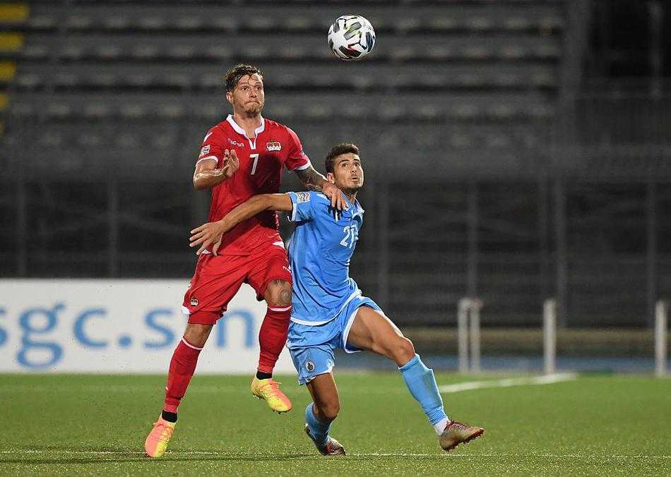 列支敦士登的锋线尖刀弗里克高高跃起，在空中划出一道完美的弧线，用一记势大力沉的头槌将球砸入网窝。在他身旁试图干扰的圣马力诺后卫，此刻只能沦为庆祝的背景板，这张照片完美捕捉了进球瞬间的爆发力与失落感。