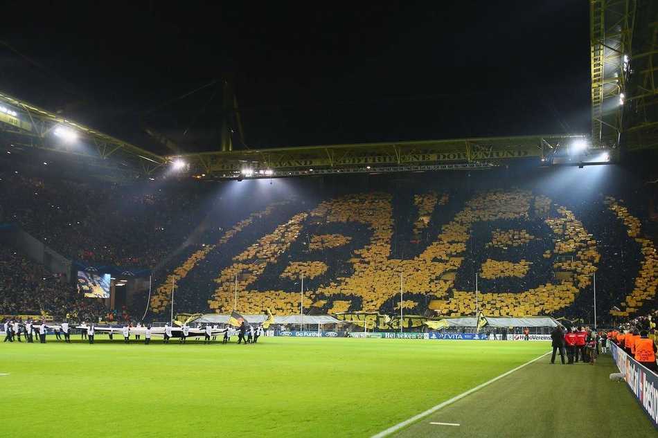 诺坎普球场在比赛日灯光璀璨，巨大的看台上坐满了红蓝拥趸，无数面队旗迎风招展，仿佛一片翻涌的海洋