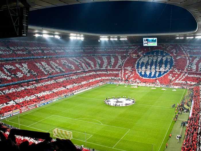 伯纳乌球场的全景图，白色座椅与白色球衣交相辉映，皇家马德里的队徽在球场中央格外醒目，尽显高贵与荣耀