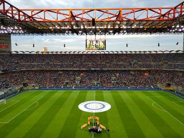 沙尔克04的费尔廷斯竞技场内部，座无虚席的看台散发着蓝色的光芒，球迷们高举围巾，营造出德甲独有的壮观场面