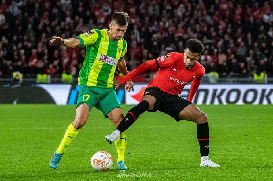 雷恩前锋带球突入禁区，面对两名防守球员的包夹，神情专注寻找射门角度