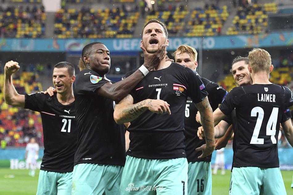 赛场上，事件主角阿瑙托维奇（左）与北马其顿球员阿利奥斯基（右）面对面站立，空气中充满了火药味。阿瑙托维奇眼神凌厉，手指着对方，似乎仍在争论着什么，旁边的队友则警惕地关注着事态发展。