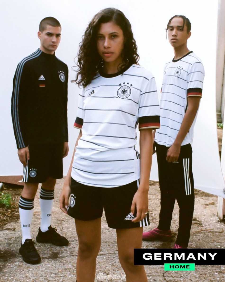 德国队的白色战袍这次玩起了时空穿梭，胸前的黑红金三色国旗条纹交错成十字，精准复刻了1990与2014两届世界杯冠军荣耀的经典轮廓。