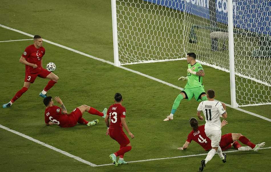 英格兰门将皮克福德在点球大战失利后，无奈地叉腰站在球门前，身后的看台上是狂欢的意大利球员，他低垂的头颅与热闹的背景形成了一幅令人心碎的剪影