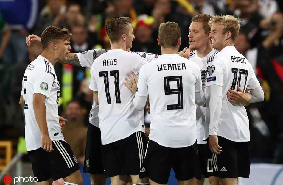 英格兰太子爷福登在雨战中搓射远角，皮球划出的弧线与看台上三狮球迷挥舞的旗帜交相辉映