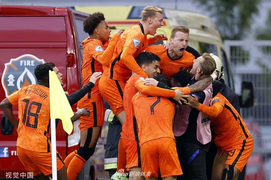荷兰U21球员们赛后紧紧相拥，脸上洋溢着胜利的喜悦，与身旁沮丧的法国队员形成鲜明对比
