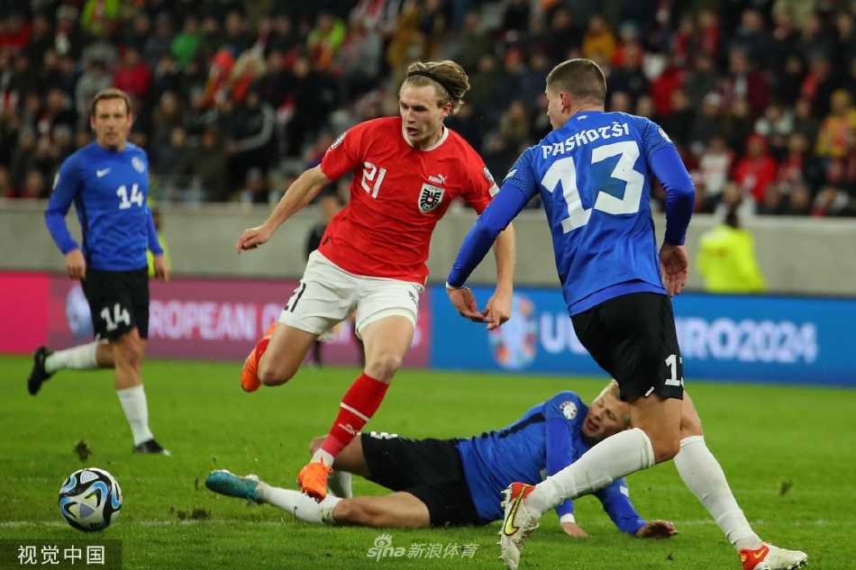 看台上奥地利小球迷脸上画着国旗，眼含热泪高举双手，身后是无数挥舞的红色旗帜