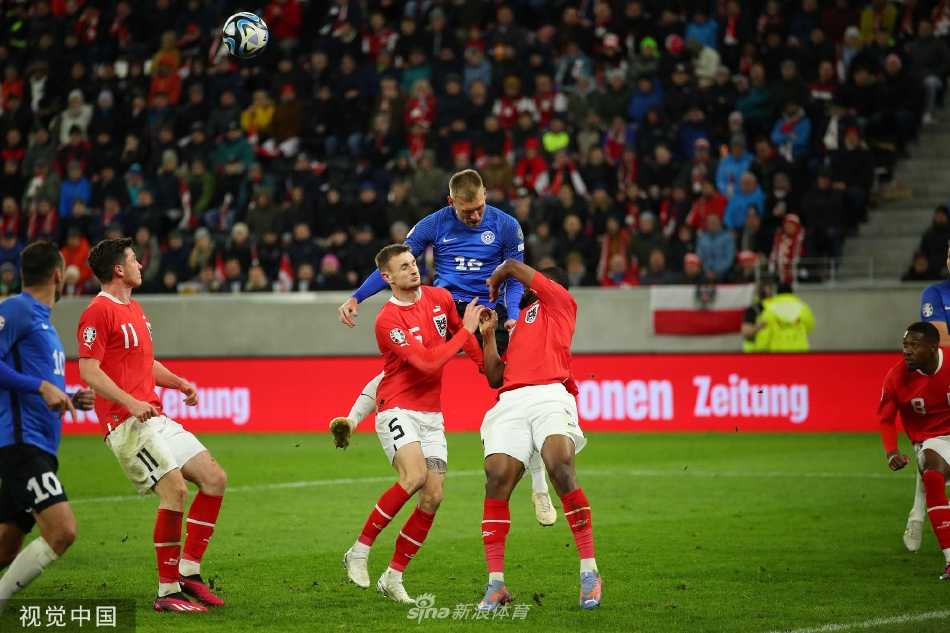 绝杀球进网瞬间特写，皮球在球网中剧烈旋转荡起涟漪，背景是呆若木鸡的爱沙尼亚门将