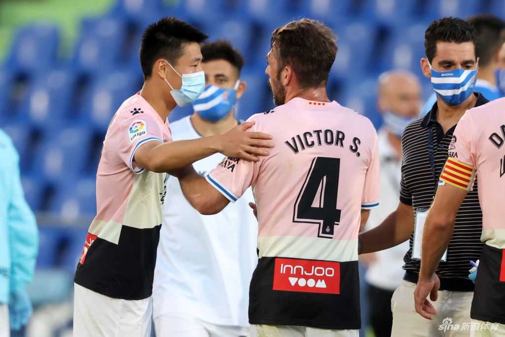 武磊在赫塔费主场护球突围，深色球衣的他在对方白绿相间防线的围剿下，眼神坚毅如铁，犹如孤胆英雄般捍卫着球队的火种。