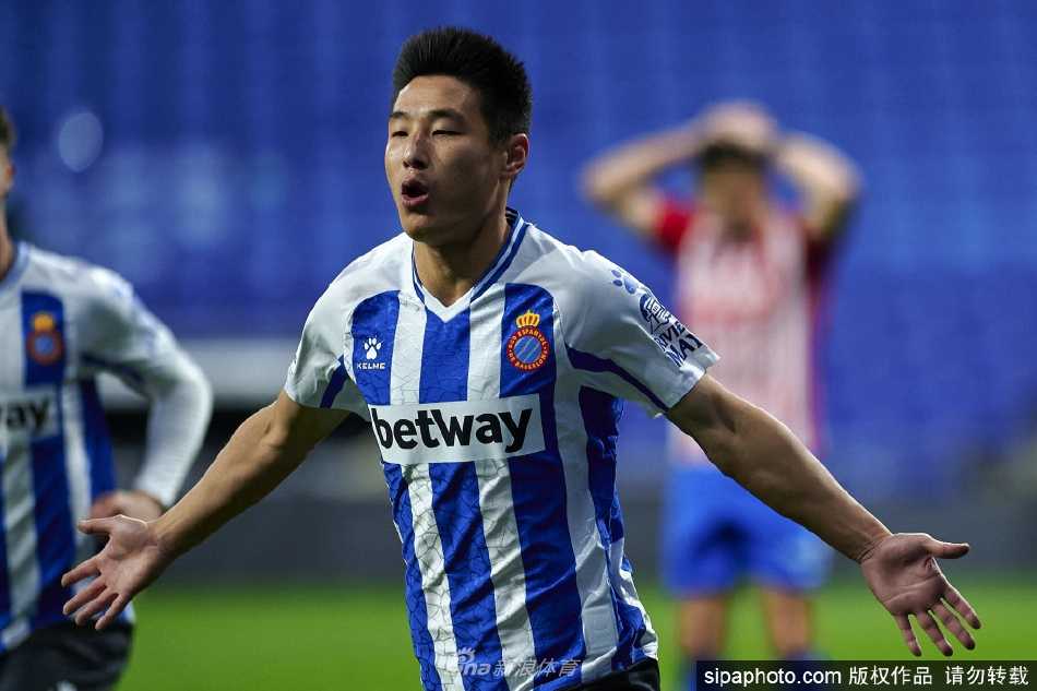 武磊手捧金球奖杯凝视远方，眼中闪烁着坚定与梦想的光芒