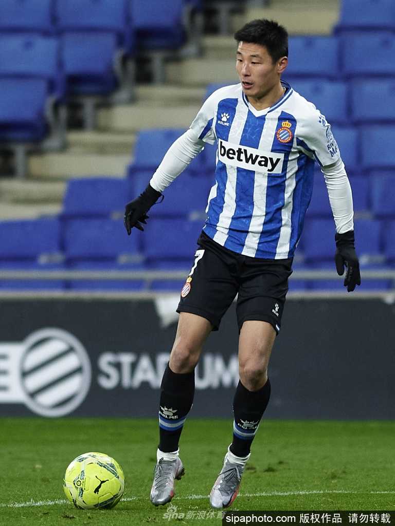 武磊高举奖杯向观众致意，灿烂笑容中洋溢着胜利的喜悦与自豪