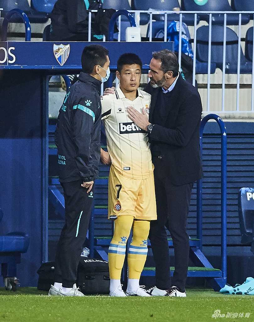 场边的武磊正在进行热身，神情专注而严肃，每一次拉伸和折返跑都充满了力量，为即将到来的登场做最后准备。