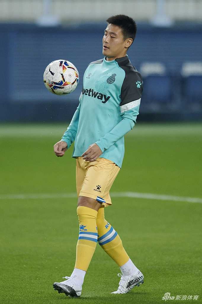 武磊在边路护球，面对马拉加防守球员的贴身逼抢，他沉着地用身体卡住位置，眼神冷静地观察着场上的局势。