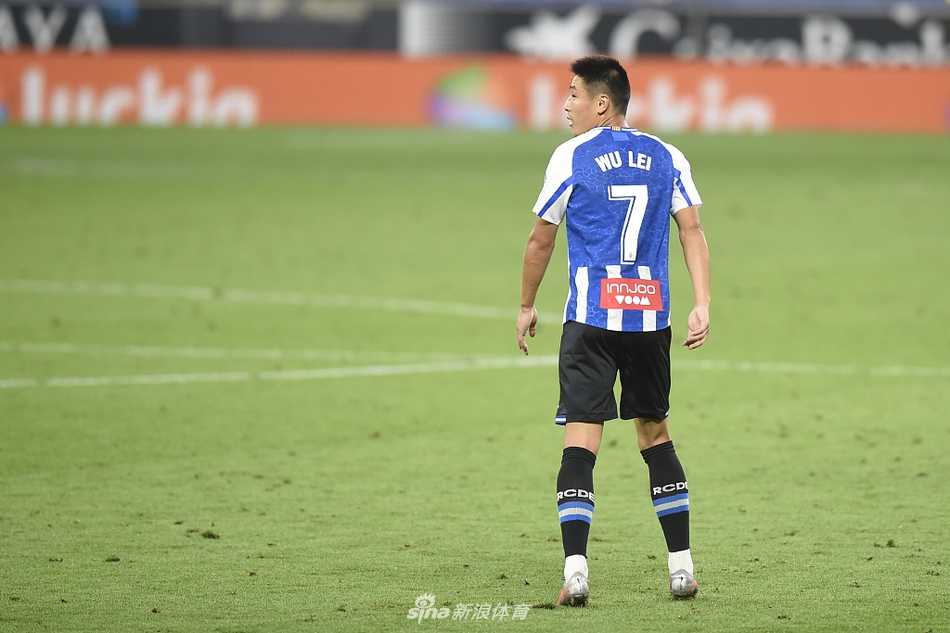 武磊在边路高速突破，面对防守球员的贴身逼抢，眼神坚定地观察着队友的跑位，准备送出致命一传