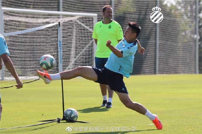 武磊在训练间隙与队友轻松交流，他的微笑感染了整个团队，预示着新赛季的更衣室氛围融洽且充满斗志。