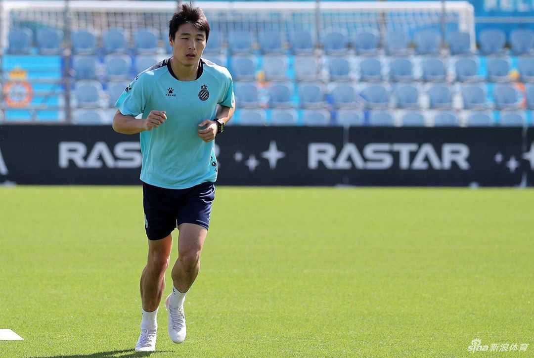 理完发后，武磊手持自己的手机，背景是简洁的理发店墙壁。他眼神明亮有神，嘴角微微上扬，整个人的气质因为发型的改变而显得格外清爽干练。