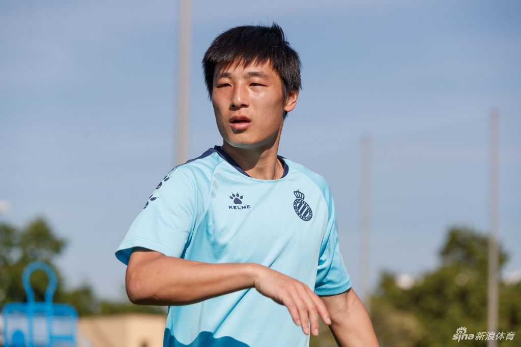 理发店内的镜子前，武磊侧身站立，目光坚定地看向镜中的自己。新剪的短发干净利落，他与身后的理发师保持着安全的防疫距离，记录下这个期待已久的瞬间。