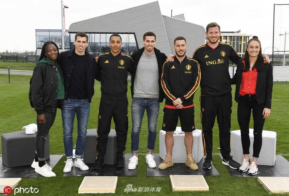 面带灿烂笑容的扎球王阿扎尔，正躬身将自己的手掌稳稳按压在湿润的水泥板上，为比利时蒂比兹的星光大道留下专属印记。