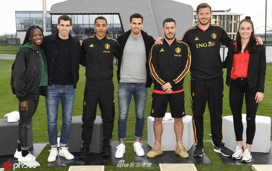 比利时门神库尔图瓦神情专注地蹲在地上，用指尖仔细勾勒着自己留下的印记，一旁队友的目光中满是欣赏与调侃。