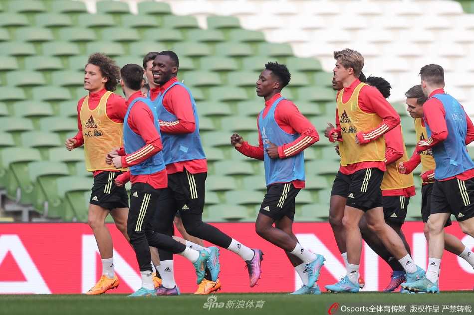 比利时球员在训练中专注地进行传接球配合，皮球在绿茵场上划出一道精准的轨迹