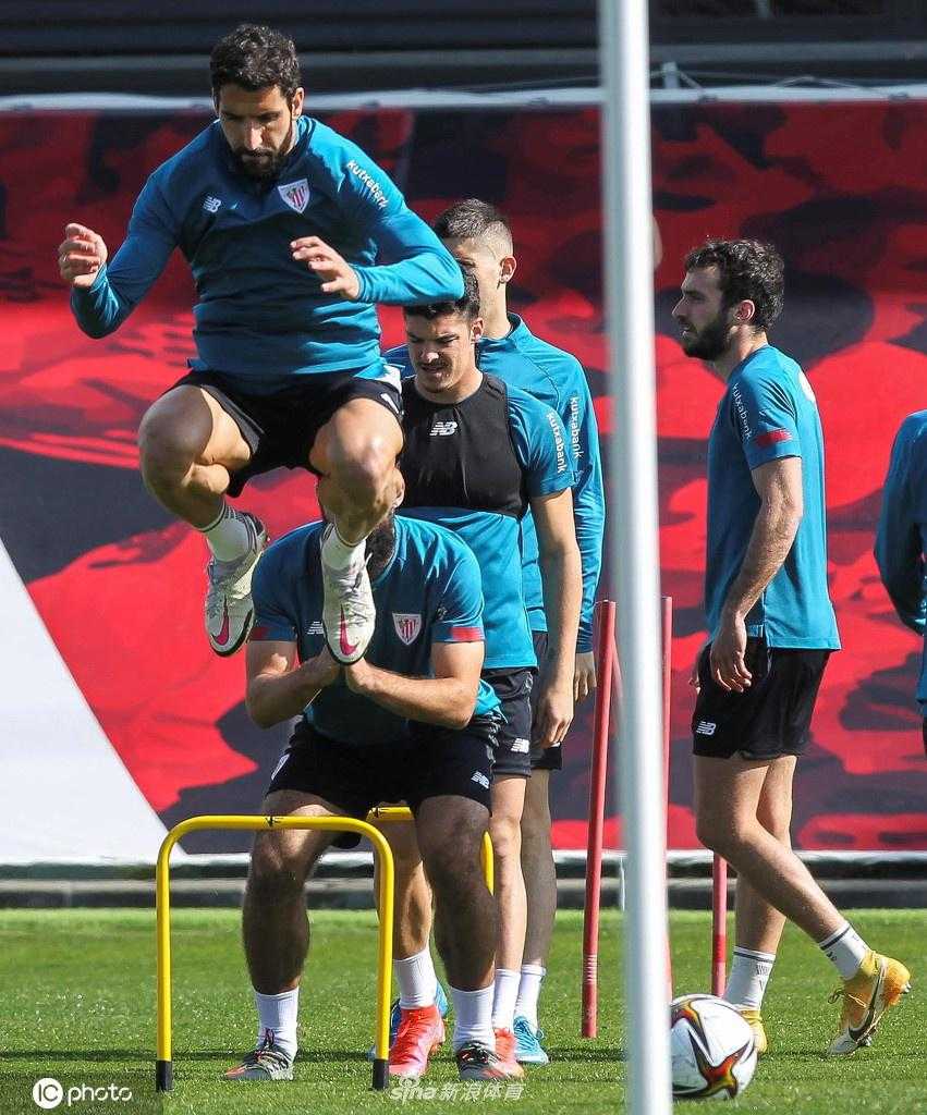 夕阳的余晖将训练场染成金色，一名毕尔巴鄂竞技球员正在进行射门练习，他轰出的足球如出膛炮弹般直奔球门死角，象征着球队向冠军发起最后冲击的决心。