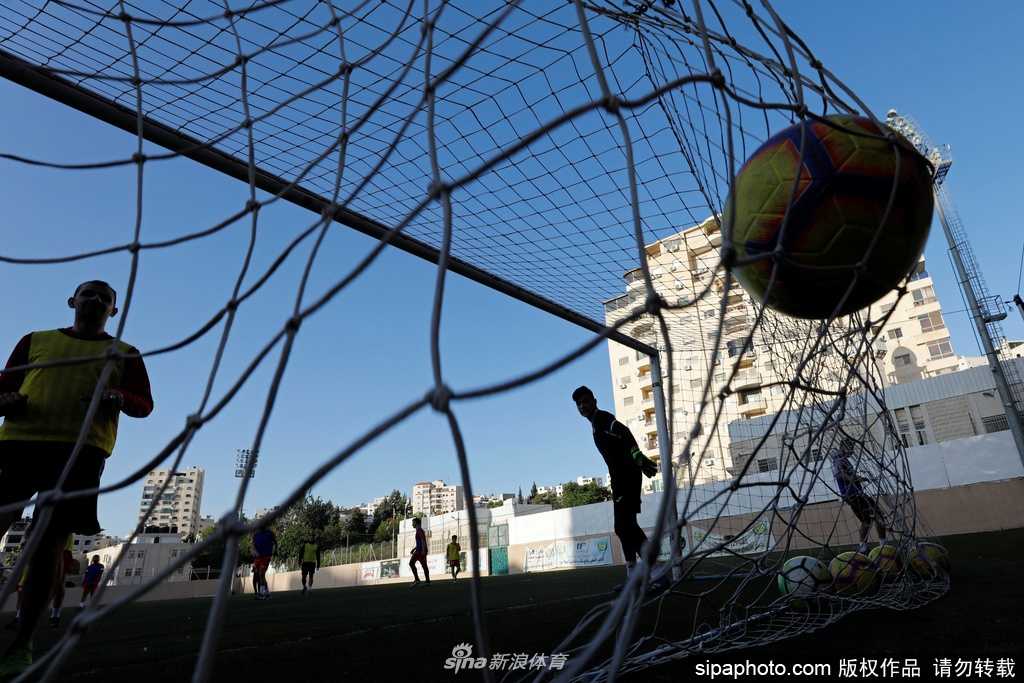 训练场上，一名阿赫利球员正独自进行带球绕杆练习，他的动作轻快而专注，身旁的敏捷梯和训练标志碟整齐摆放，预示着球队正从基础体能向技术训练过渡。